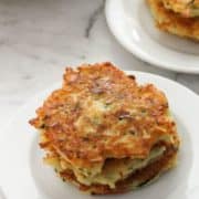 stack of fritters on a plate with a bowl of potatoes in the background and text overlay "potato fritters".
