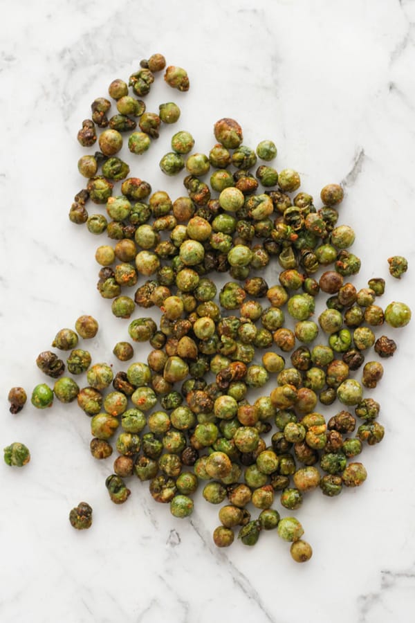crunchy roasted peas on a marble countertop.