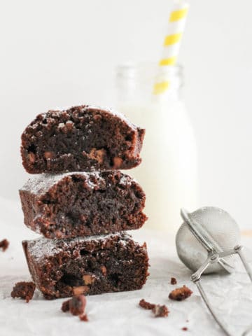 stack of brownies next to a bottle of milk.