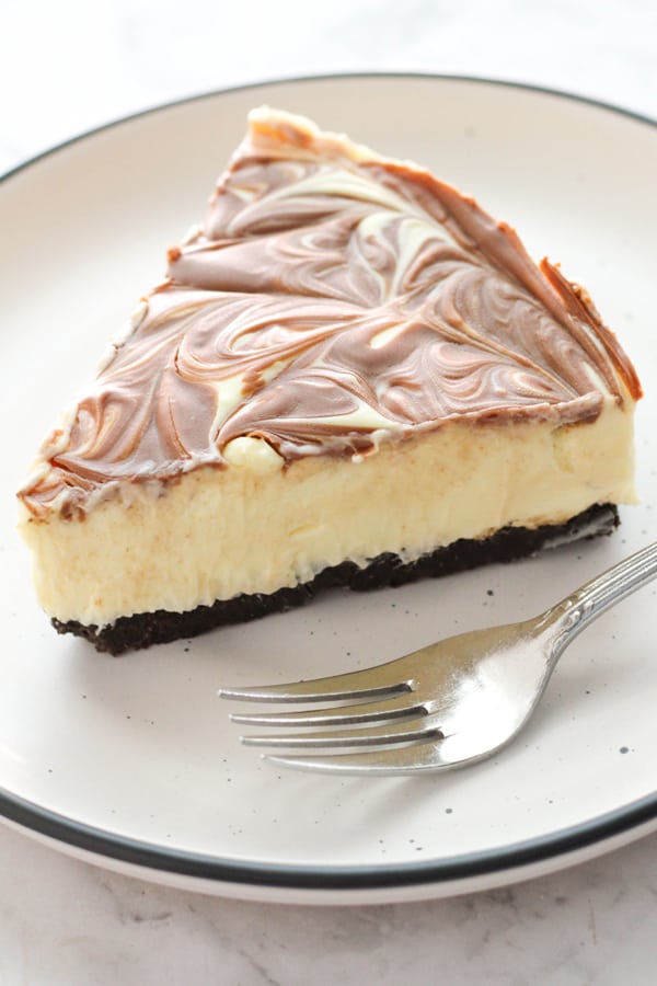 a slice of marble cheesecake with a fork on the plate.