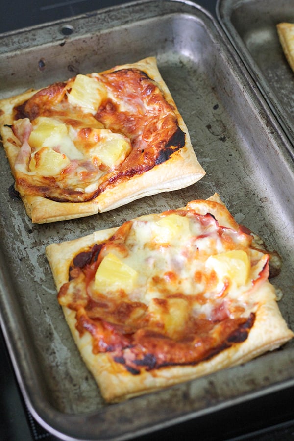 puff pastry pizzas on a baking tray.