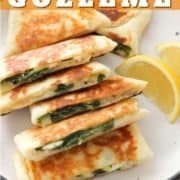 gozleme stacked on top of each other on a white plate with text overlay "spinach & feta gozleme".