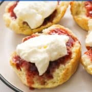 scone topped with jam and cream on a plate with text overlay "air fryer scones".
