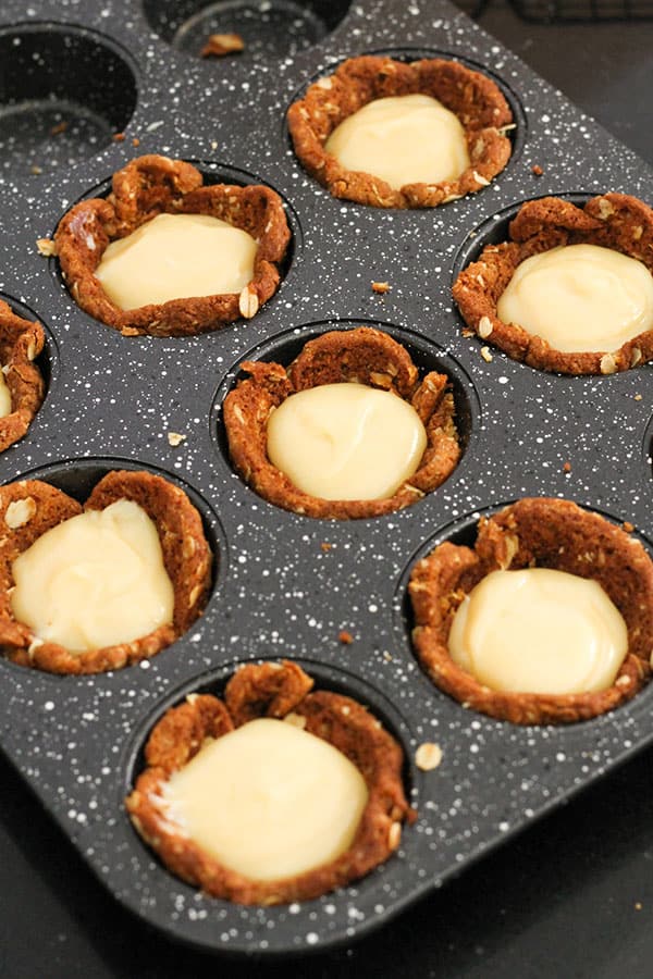 caramel filled tart cases in a muffin tray.