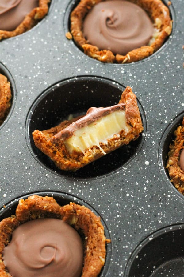 mini caramel tart with a bite removed in a muffin tin.