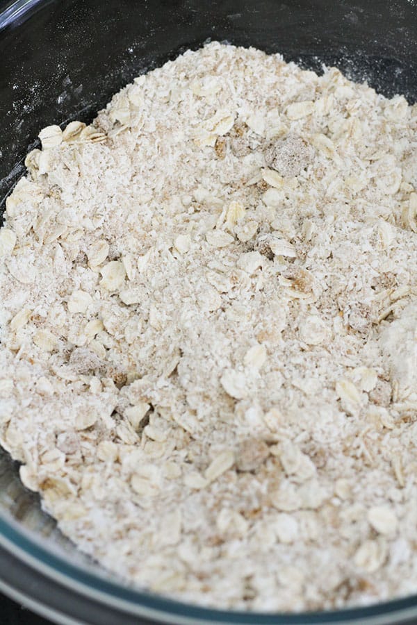 flour, rolled oats, brown sugar and coconut in a glass bowl.