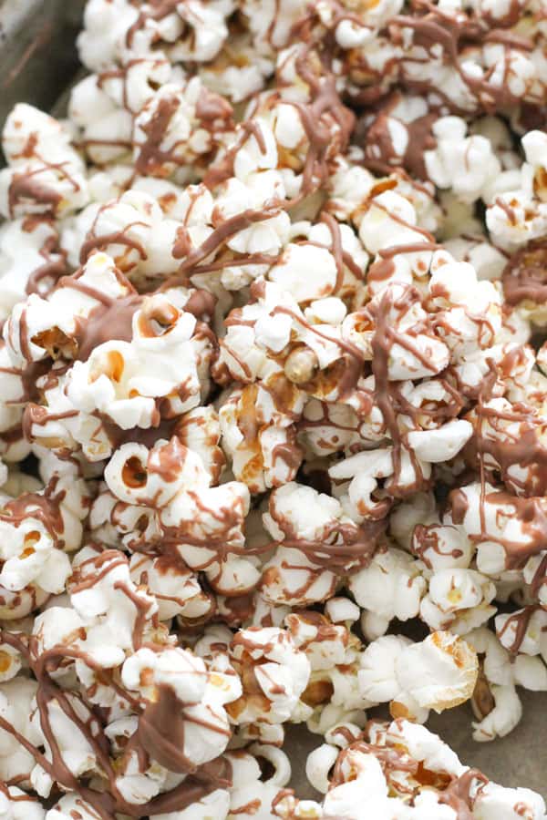 chocolate drizzled popcorn on a tray.