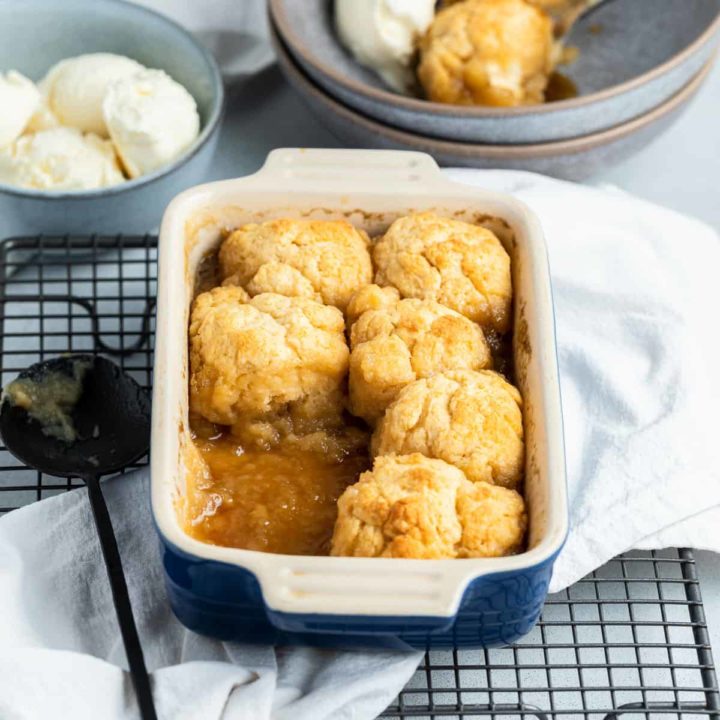 golden syrup dumplings in a baking dish on top of a wire tray.
