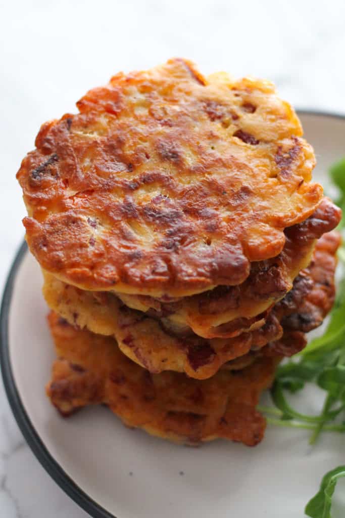fritters stacked up high on a white plate.