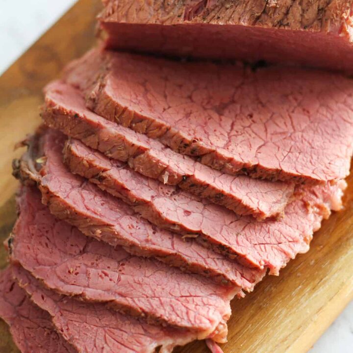 slices of corned beef on a wooden board.