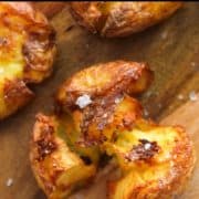 a crispy potato sitting on a wooden board with text overlay "air fryer smashed potato".