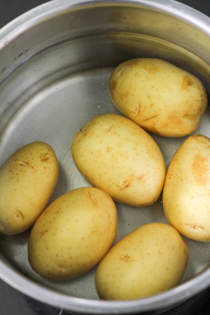 small potatoes in a saucepan filled with water.